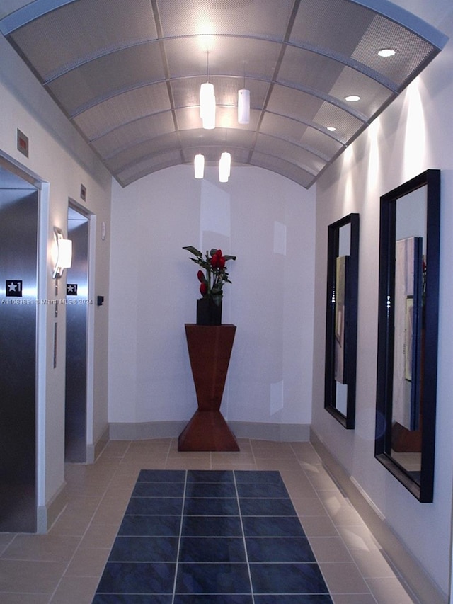 hall featuring lofted ceiling and tile patterned floors