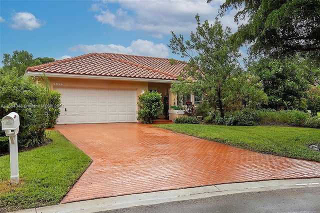 mediterranean / spanish house with a garage and a front lawn