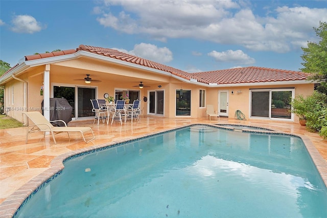 view of swimming pool featuring area for grilling, ceiling fan, and a patio area