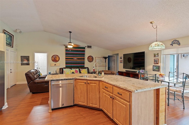 kitchen featuring lofted ceiling, dishwasher, a kitchen island with sink, sink, and light hardwood / wood-style floors