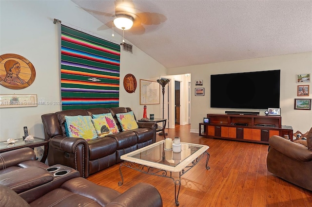 living room with lofted ceiling, a textured ceiling, hardwood / wood-style flooring, and ceiling fan