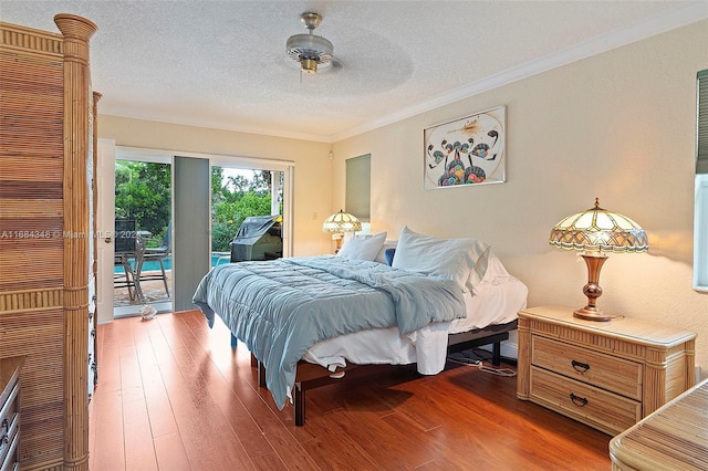 bedroom with ceiling fan, a textured ceiling, access to exterior, ornamental molding, and dark hardwood / wood-style floors