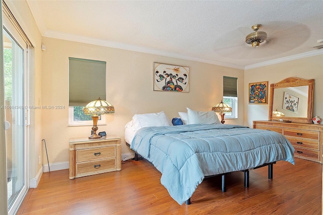 bedroom featuring access to outside, light hardwood / wood-style flooring, ornamental molding, a textured ceiling, and ceiling fan