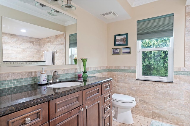 bathroom featuring tile walls, toilet, vanity, crown molding, and tile patterned flooring