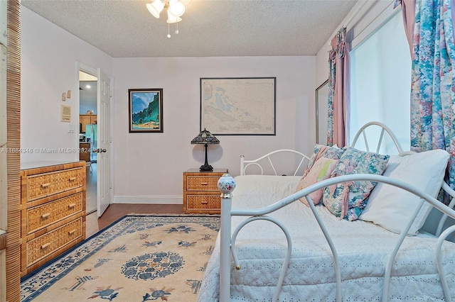 bedroom with ceiling fan and a textured ceiling