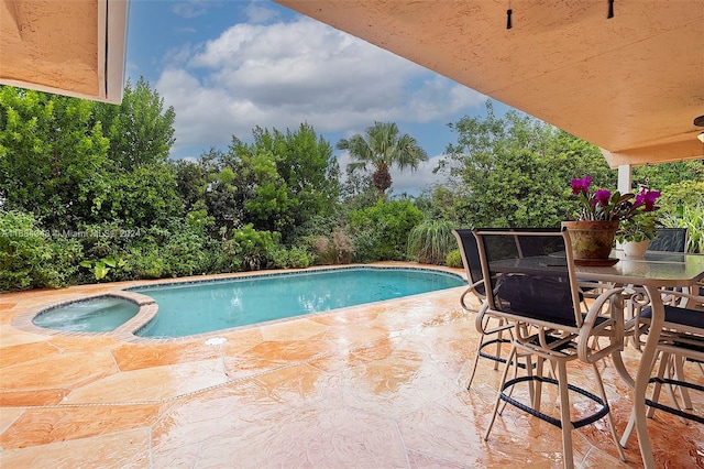 view of pool featuring a patio area and an in ground hot tub