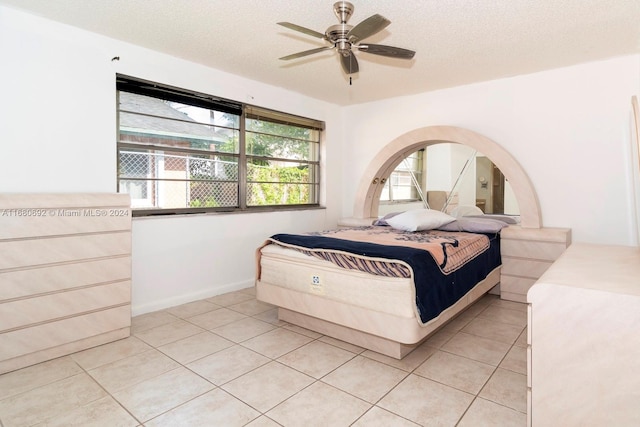 bedroom featuring ceiling fan, a textured ceiling, and light tile patterned floors