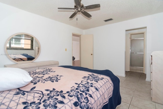 tiled bedroom with a textured ceiling and ceiling fan