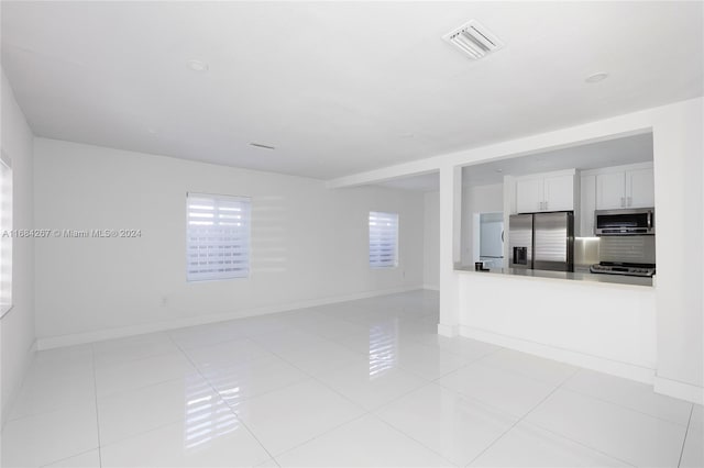 unfurnished living room featuring light tile patterned floors