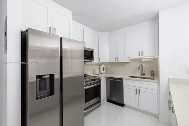 kitchen featuring stainless steel appliances, white cabinetry, sink, and light tile patterned floors