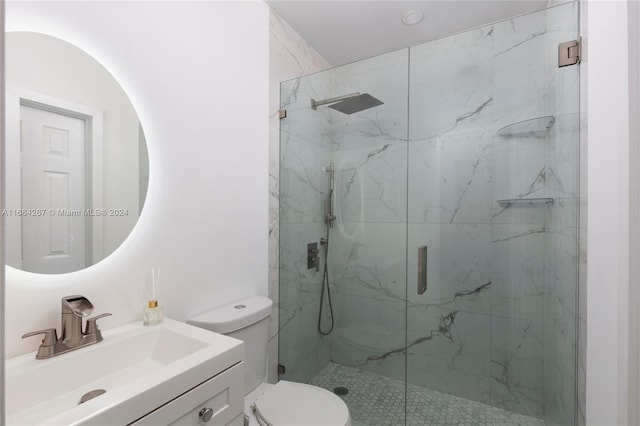 bathroom featuring vanity, toilet, and a shower with door