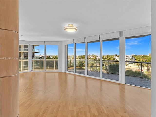 unfurnished room featuring expansive windows and wood-type flooring