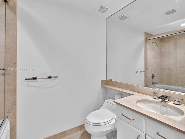 full bathroom featuring toilet, tiled shower / bath, vanity, and tile patterned flooring