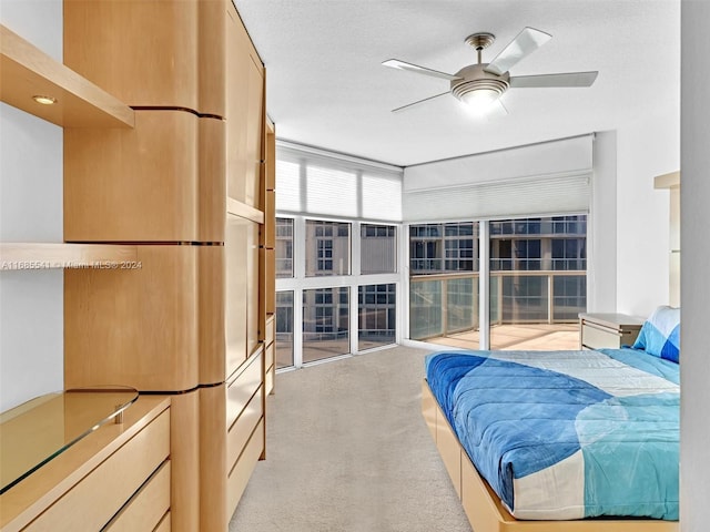 bedroom with ceiling fan, a textured ceiling, and light colored carpet