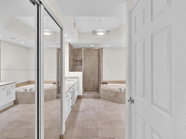 bathroom with vanity, a raised ceiling, tile patterned floors, and shower with separate bathtub