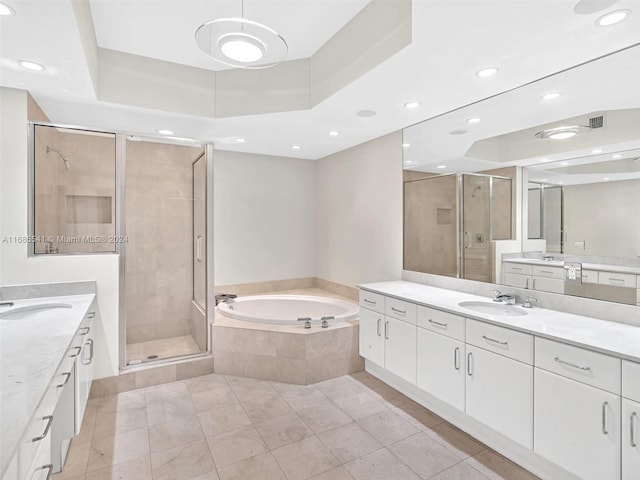 bathroom featuring vanity, shower with separate bathtub, a tray ceiling, and tile patterned floors