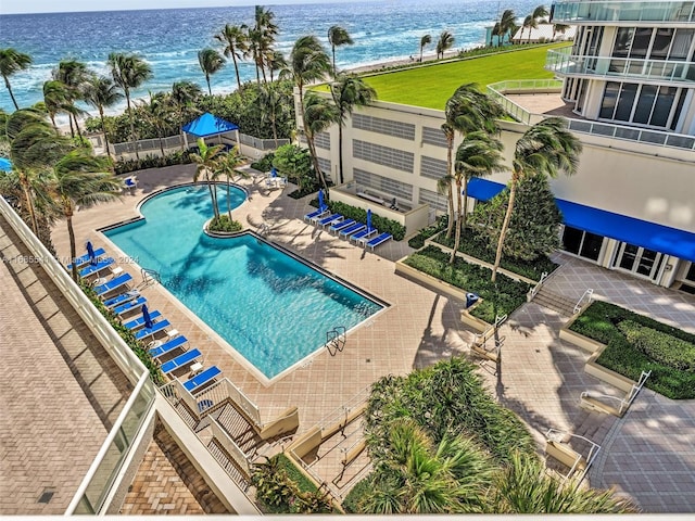 view of pool featuring a water view and a patio