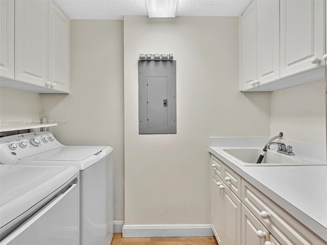 washroom with light hardwood / wood-style flooring, independent washer and dryer, sink, cabinets, and electric panel