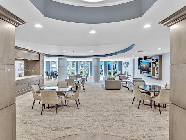 dining space featuring light hardwood / wood-style floors and a tray ceiling