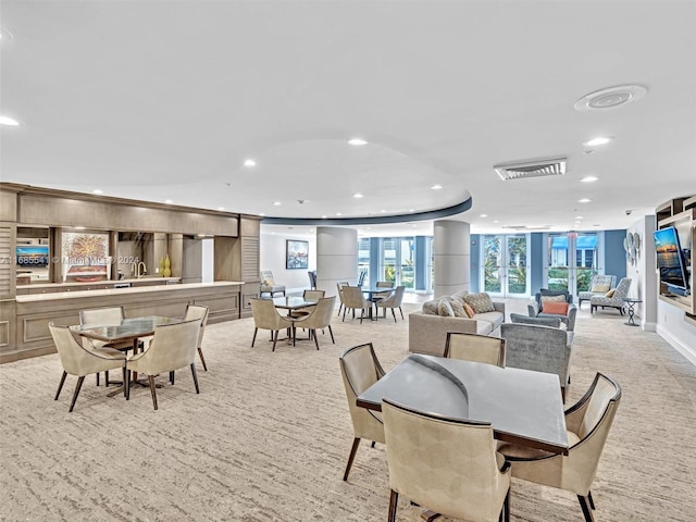 carpeted dining room featuring a raised ceiling