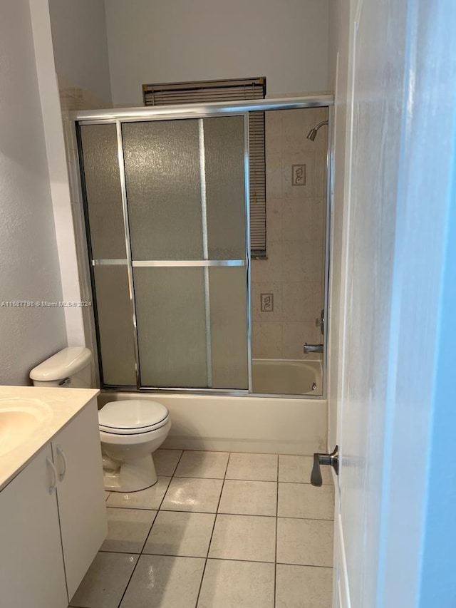 full bathroom with toilet, bath / shower combo with glass door, vanity, and tile patterned floors