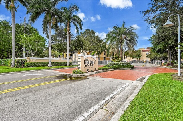 519 E Sheridan St Unit 106, Dania Beach, FL 33004 - view of asphalt road featuring curbs, street lighting, a gate, and a gated entry