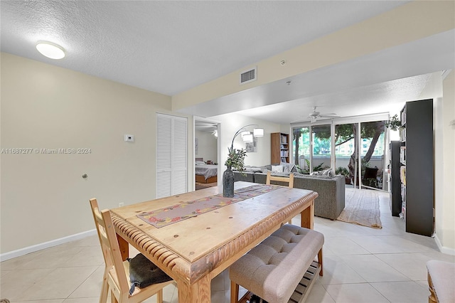 dining space with ceiling fan, light tile patterned floors, and a textured ceiling