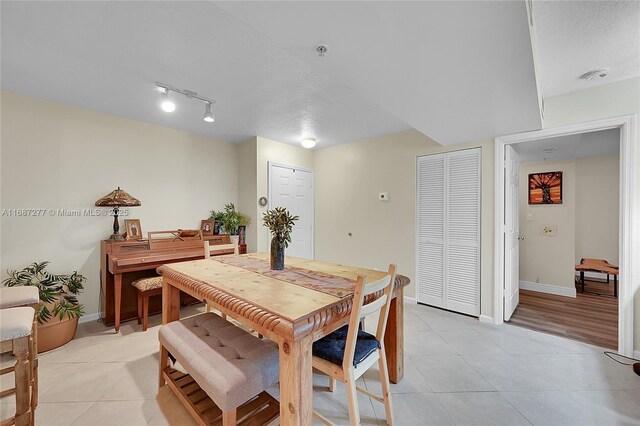 519 E Sheridan St Unit 106, Dania Beach, FL 33004 - dining space with light tile patterned flooring, a textured ceiling, and rail lighting