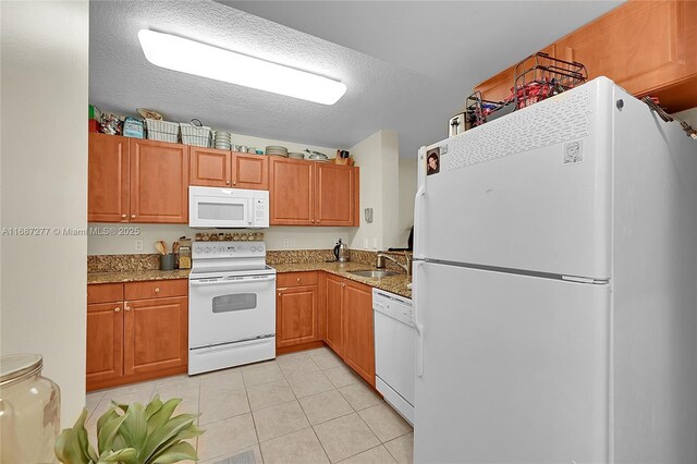519 E Sheridan St Unit 106, Dania Beach, FL 33004 - kitchen with white appliances, light tile patterned flooring, a textured ceiling, light stone countertops, and brown cabinetry