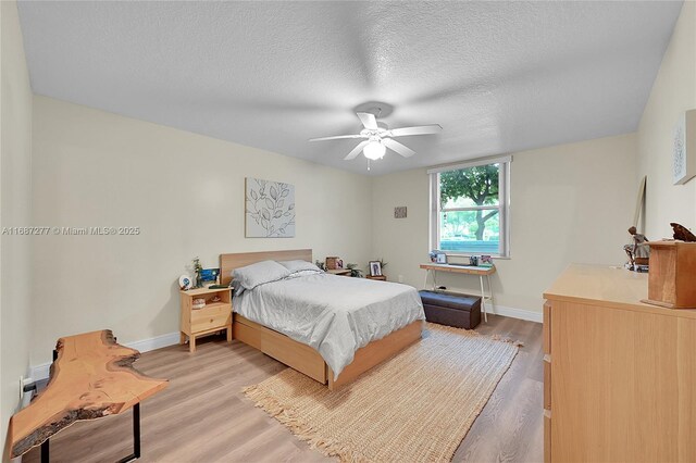 519 E Sheridan St Unit 106, Dania Beach, FL 33004 - bedroom featuring light wood-style flooring, a textured ceiling, and ceiling fan