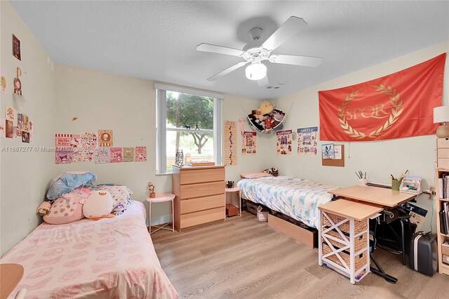 519 E Sheridan St Unit 106, Dania Beach, FL 33004 - bedroom with light wood finished floors, ceiling fan, and a textured ceiling