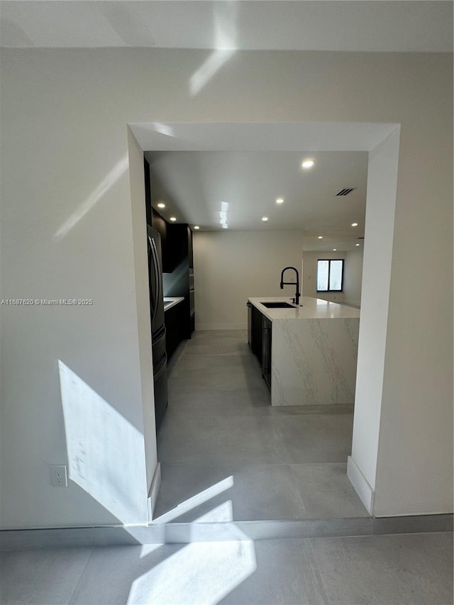 kitchen featuring stainless steel appliances, sink, and a center island with sink