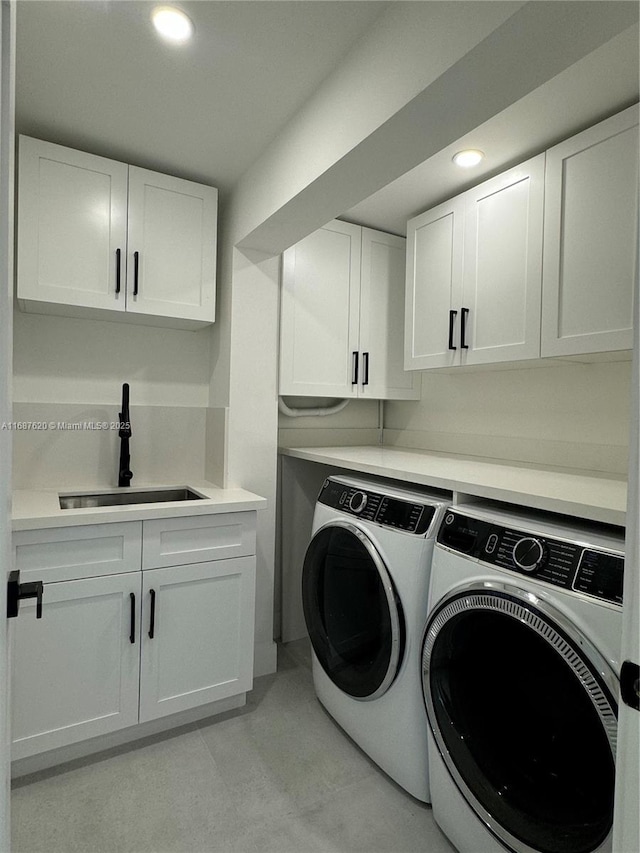 washroom featuring recessed lighting, washer and dryer, cabinet space, and a sink