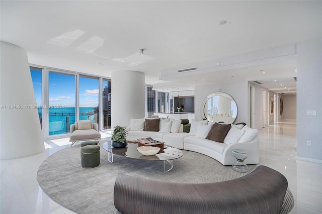 living room with a water view, light tile patterned floors, and floor to ceiling windows