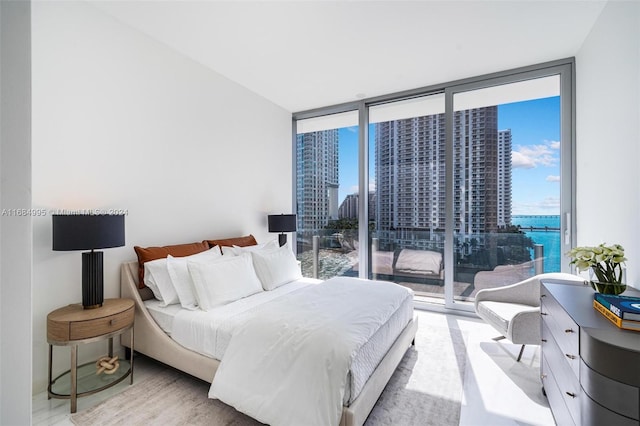 bedroom with a wall of windows, multiple windows, and access to exterior