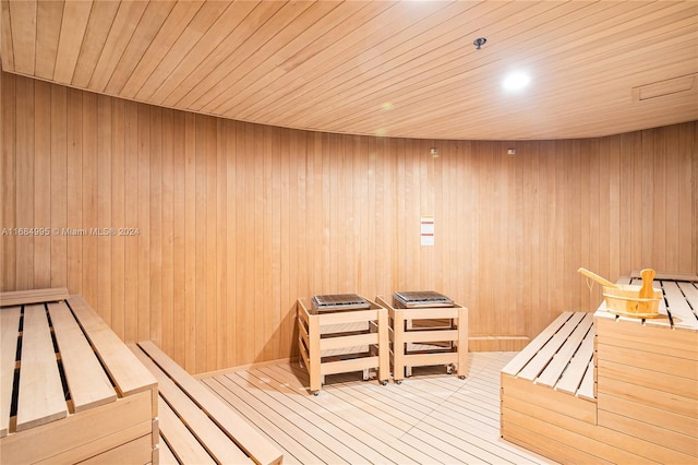 view of sauna / steam room featuring hardwood / wood-style flooring, wooden ceiling, and wood walls