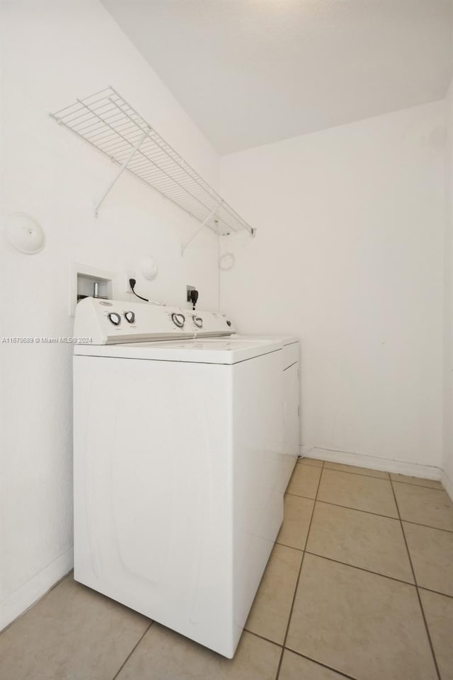 washroom with washer and clothes dryer and light tile patterned floors