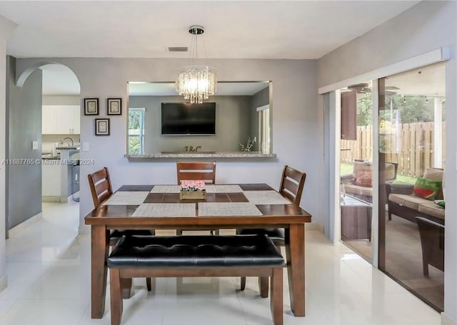 dining area featuring a chandelier, a healthy amount of sunlight, and light tile patterned floors