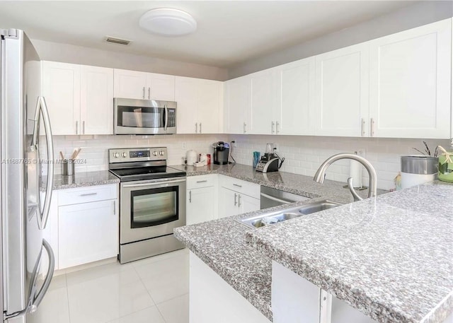 kitchen featuring backsplash, sink, appliances with stainless steel finishes, and white cabinets