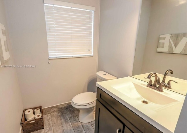 bathroom featuring toilet, hardwood / wood-style floors, and vanity