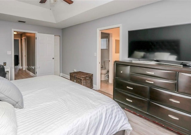 bedroom featuring light hardwood / wood-style flooring, ensuite bathroom, and ceiling fan