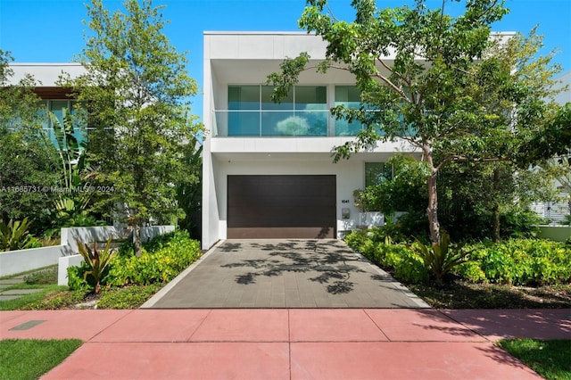 contemporary house with a garage and a balcony