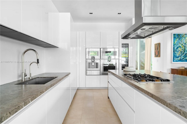 kitchen with white cabinetry, sink, and range hood