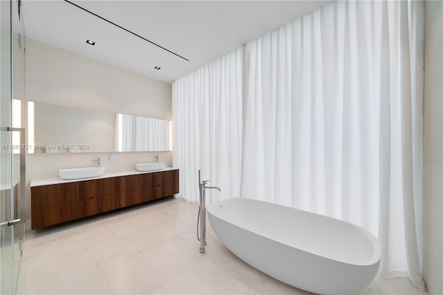 bathroom featuring independent shower and bath, vanity, and tile walls