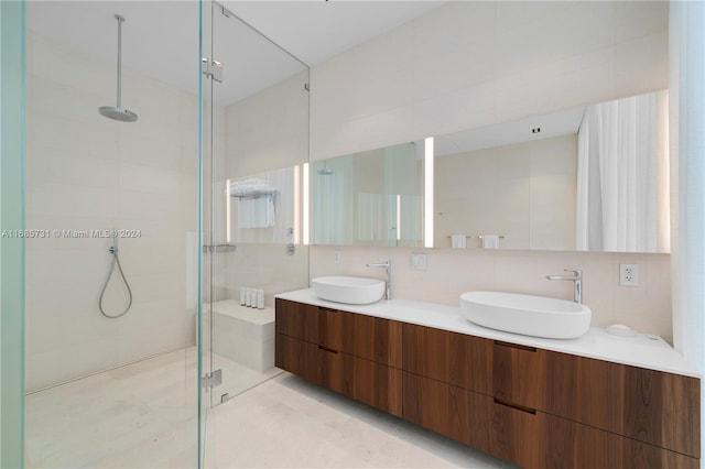 bathroom with tile patterned floors, tile walls, tasteful backsplash, an enclosed shower, and vanity