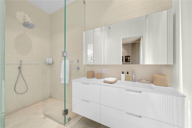 bathroom featuring tile walls, an enclosed shower, vanity, and backsplash