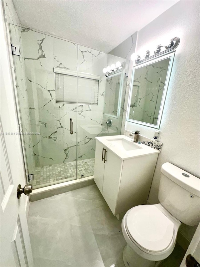 bathroom with toilet, an enclosed shower, a textured ceiling, and vanity