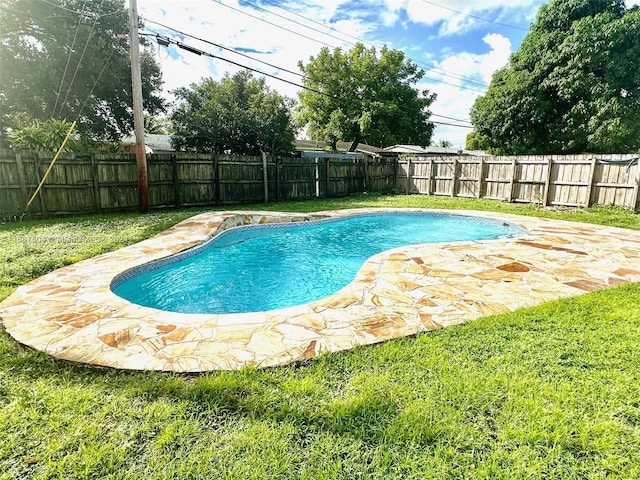 view of pool with a patio area and a yard