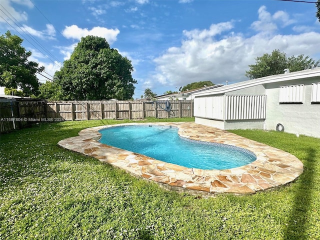 view of pool with a patio area and a yard