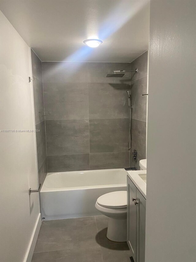 full bathroom featuring toilet, tiled shower / bath combo, vanity, and tile patterned floors